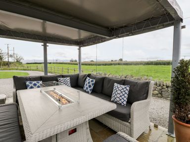 An outdoor seating area with a sofa and table at Cae Sam in Pentraeth