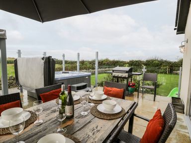 An outdoor dining area with a table and chairs at Cae Sam in Pentraeth
