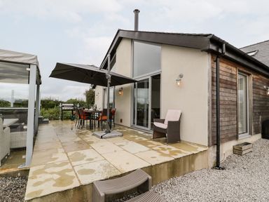 A patio with a table and chairs at Cae Sam in Pentraeth