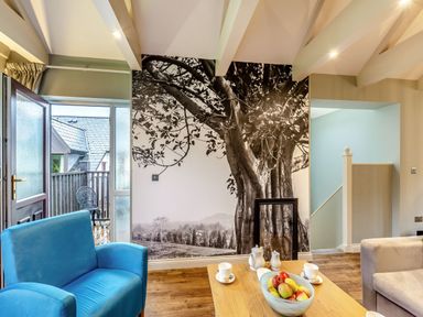 A living room with a door and a wall art at The Whitbarrow Den in Penrith