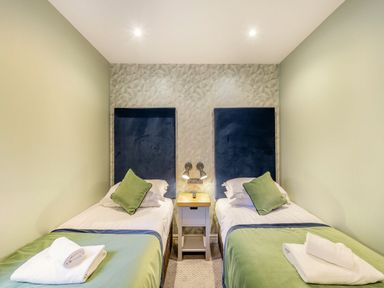 A bedroom with two beds and a nightstand at The Whitbarrow Den in Penrith