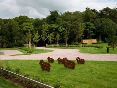 An outdoor area with sheep sculptures and a pathway at Fell Side in Penrith