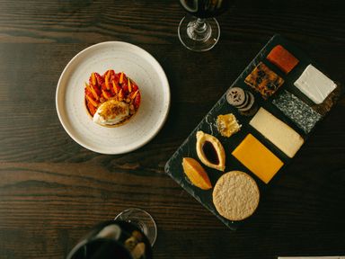 A cheese board with various cheeses and a dessert on a plate at Fell Side in Penrith