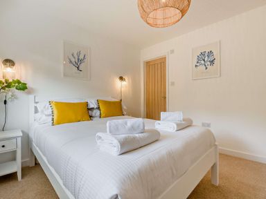 A bedroom with a bed and bedside table at Klys 1.0 Spa in Perranporth