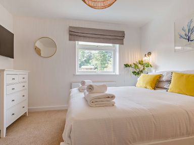 A bedroom with a bed and dresser at Klys 1.0 Spa in Perranporth