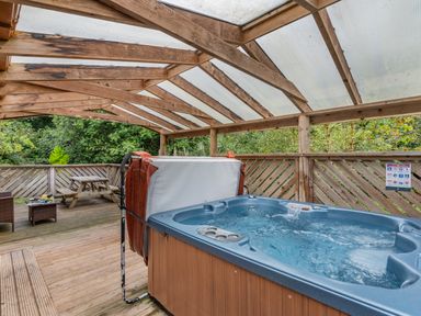 An outdoor area with a hot tub and seating at Poldark Spa Pet in Perranporth