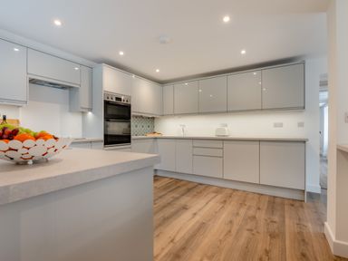 A kitchen with modern cabinets and appliances at The Farmhouse (Pet) Perranporth