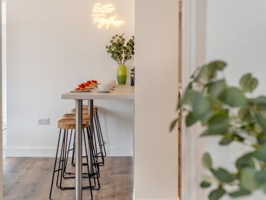 A kitchen with bar stools and a counter at The Farmhouse (Pet) Perranporth