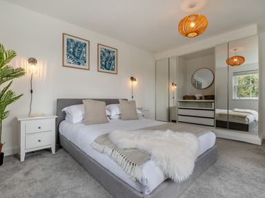 A bedroom with a bed and nightstands at The Farmhouse (Pet) Perranporth