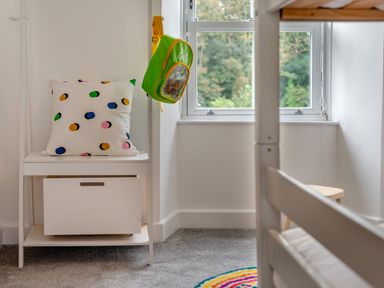 A bedroom with a pillow on a shelf and a backpack hanging at The Farmhouse (Pet) Perranporth