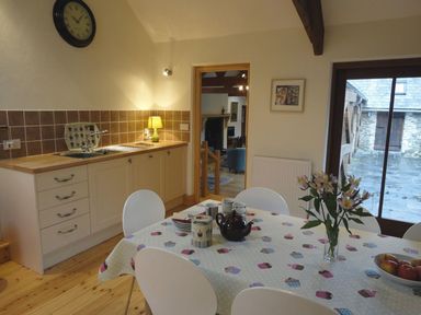 A kitchen with a table and chairs at Nethercote Byre in Minehead