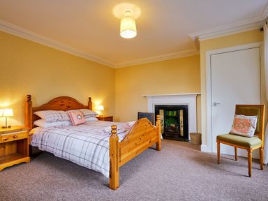 A bedroom with a bed and a fireplace at West Lodge in Kirriemuir