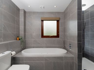A bathroom with a bathtub and toilet at The Derwent (Pet) Slaley