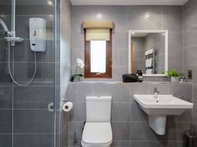 A bathroom with a shower, toilet, and sink at The Hexham in Slaley