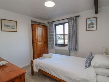 A bedroom with a single bed and wardrobe at Long Linney in Bideford