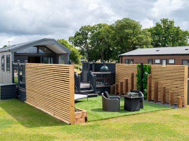 An outdoor area with a house, deck, chairs, and table at The Oasis in Great Ayton