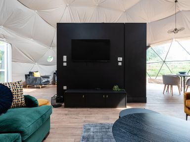 A living room with a television and chairs at The Dome (Pet) in Great Ayton