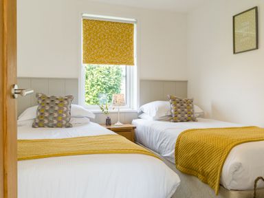 A bedroom with two beds and a window at Greystone in Great Ayton