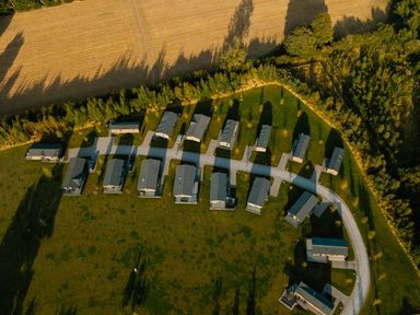 An aerial view of a cluster of cabins with a gravel road at The Woods in Great Ayton