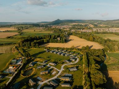 A landscape view of fields and lodges near a town at The Woods in Great Ayton