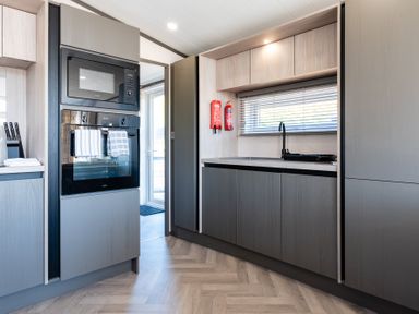 A kitchen with cabinets, an oven, and a sink at The Woods (Pet) Great Ayton