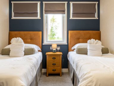 A bedroom with two beds and a nightstand at Rosedale in Great Ayton