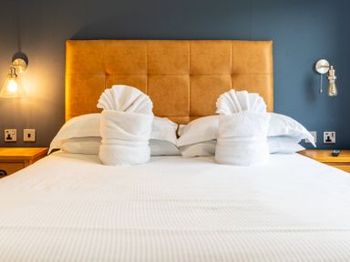 A bedroom with a bed and towel arrangements at Roseberry in Great Ayton