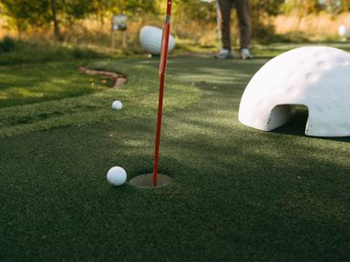 A putting green with golf balls and a hole at Roseberry in Great Ayton