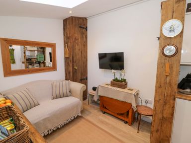 A living room with a sofa and television at Flat 4 in Evesham