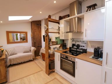A kitchen with a sofa and mirror at Flat 4 in Evesham