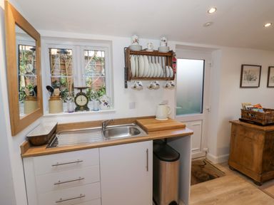 A kitchen with a sink, countertop, and dishes on a rack at Flat 4 in Evesham