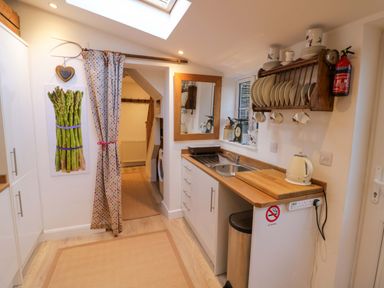 A kitchen with a sink and cutting board at Flat 4 in Evesham