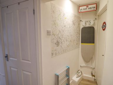A hallway with a map and ironing board at Flat 4 in Evesham