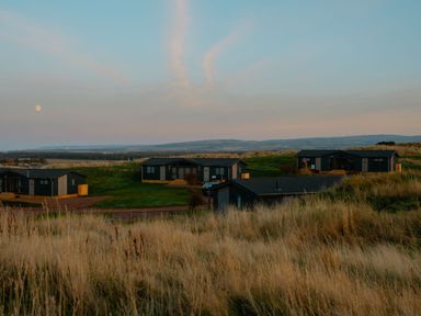 Houses on a grassy landscape under a moon at The Grays in North Berwick