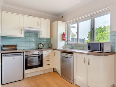 A kitchen with appliances and cabinets at 4C2 Summerleaze Garden Cottage 2 Spa Bude