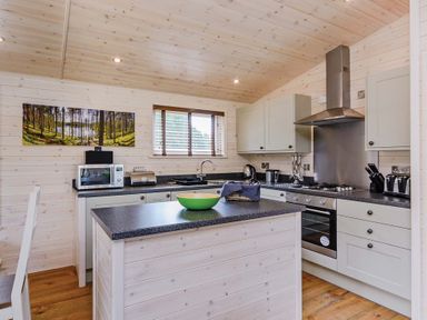 A kitchen with cabinets and a countertop at Hurricane Lodge in Fair Oak
