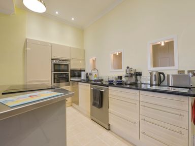 A kitchen with cabinets, oven, and sink at The Old Signal House in Torpoint