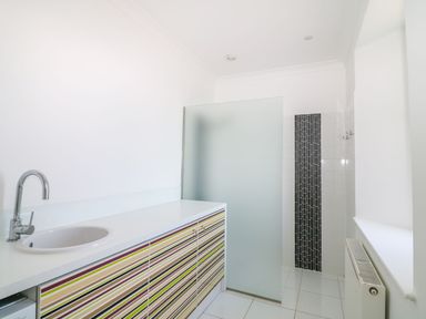 A bathroom with a cabinet and shower area at The Old Signal House in Torpoint