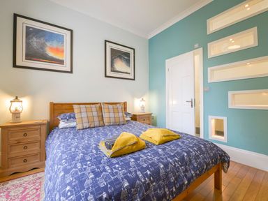 A bedroom with a bed and wall art at The Old Signal House in Torpoint