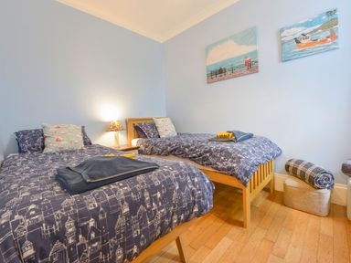 A bedroom with two beds and a lamp at The Old Signal House in Torpoint