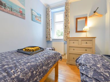 A bedroom with two beds and a chest of drawers at The Old Signal House in Torpoint