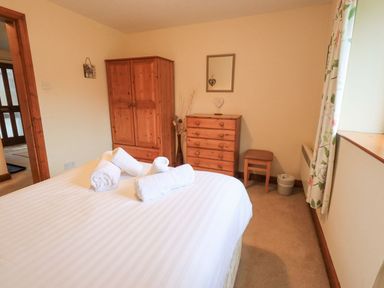 A bedroom with a bed, wardrobe, and chest of drawers at Thrang View in Chapel Stile