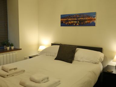 A bedroom with a bed and side tables at Rockfish Cottage in Brixham