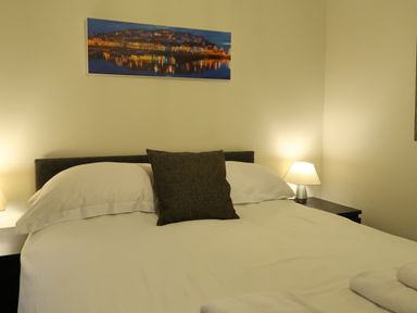 A bedroom with a bed and side table at Rockfish Cottage in Brixham