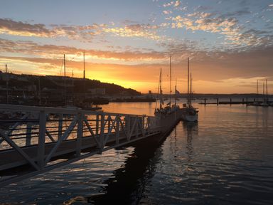 A sunset over water with boats at Rockfish Cottage in Brixham