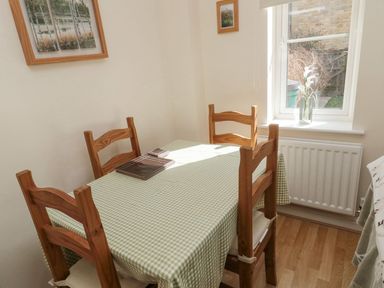 A dining room with a table and chairs at Ramblers Cottage in Alnwick