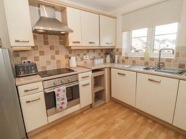 A kitchen with oven, sink, and toaster at Ramblers Cottage in Alnwick
