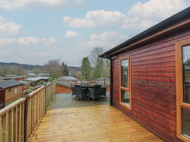 An outdoor deck with a table and chairs at High Lake View Lodge White Cross Bay near Troutbeck Bridge
