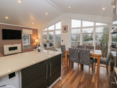 A kitchen with a dining table and chairs at High Lake View Lodge White Cross Bay near Troutbeck Bridge