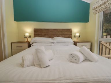 A bedroom with a bed and nightstands at High Lake View Lodge White Cross Bay near Troutbeck Bridge